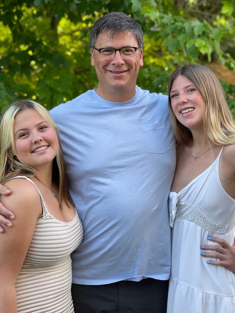 Scott Robbins standing with his daughters